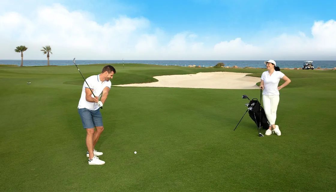 Jebel Sifah — a couple playing golf